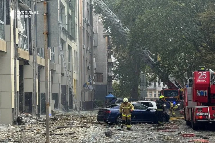 Вокруг здания разбитое стекло и поврежденный транспорт