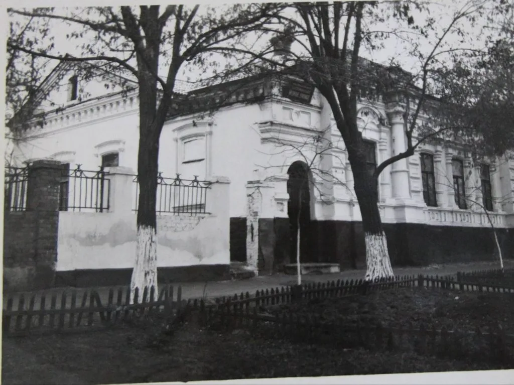 Чорно-біле архівне фото будівлі фельдшерсько-акушерської медичної професійної школи у 1926 році. Перед одноповерховою будівлею з декоративним фасадом ростуть дерева, територію від вулиці відділяє невисокий паркан
