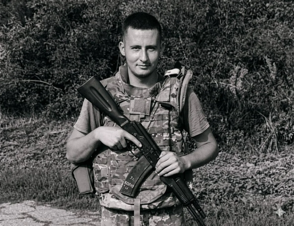 На чорно-білій світлині військовий Володимир Пилипей у камуфляжній формі й тактичному спорядженні стоїть на тлі густої рослинності й тримає автомат. Фото з архіву сімʼї
