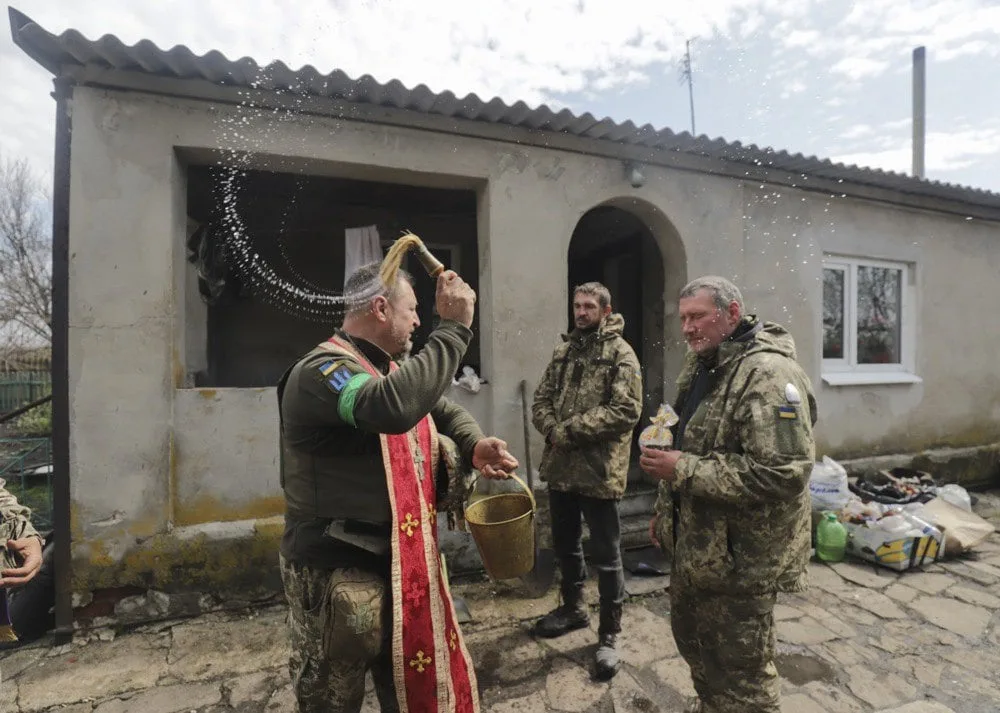Військовий капелан кропить військових свяченою водою під час святкування Великодня неподалік від їхніх позицій, Харківська обл
24 квітня 2022 року.