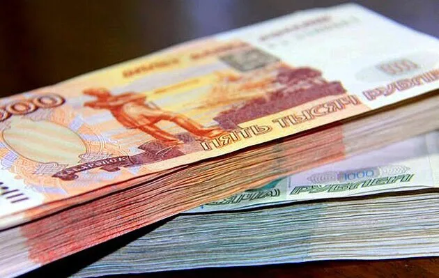 Стоси російських рублів різного номіналу, складені один на один. На верхній пачці видно банкноти номіналом п’ять тисяч рублів