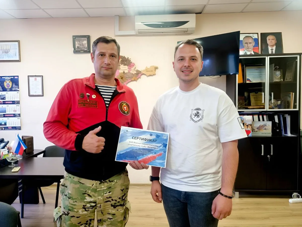 Олексій Зінченко, так званий голова Держкомітету молодіжної політики Республіки Крим (у білій футболці) вручає сертифікат за участь у конкурсі Олексію Ілляшенку, керівнику ВПК «Богатир» і колишньому працівнику Головного управління МНС України в АР Крим