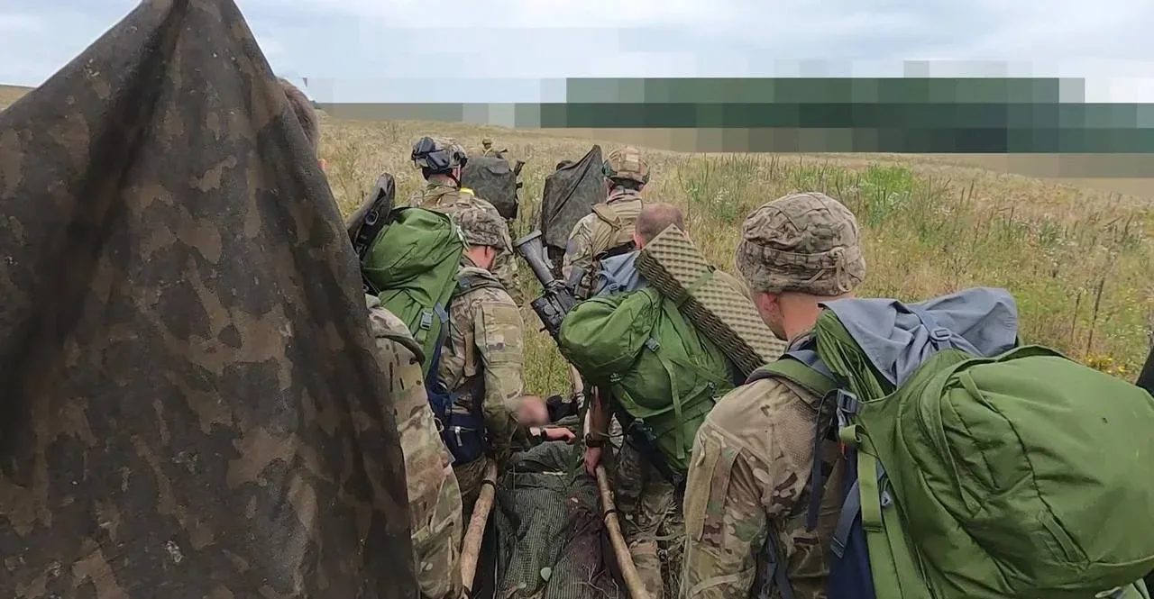 Бійці ССО квакуюють пораненого побратима через поле