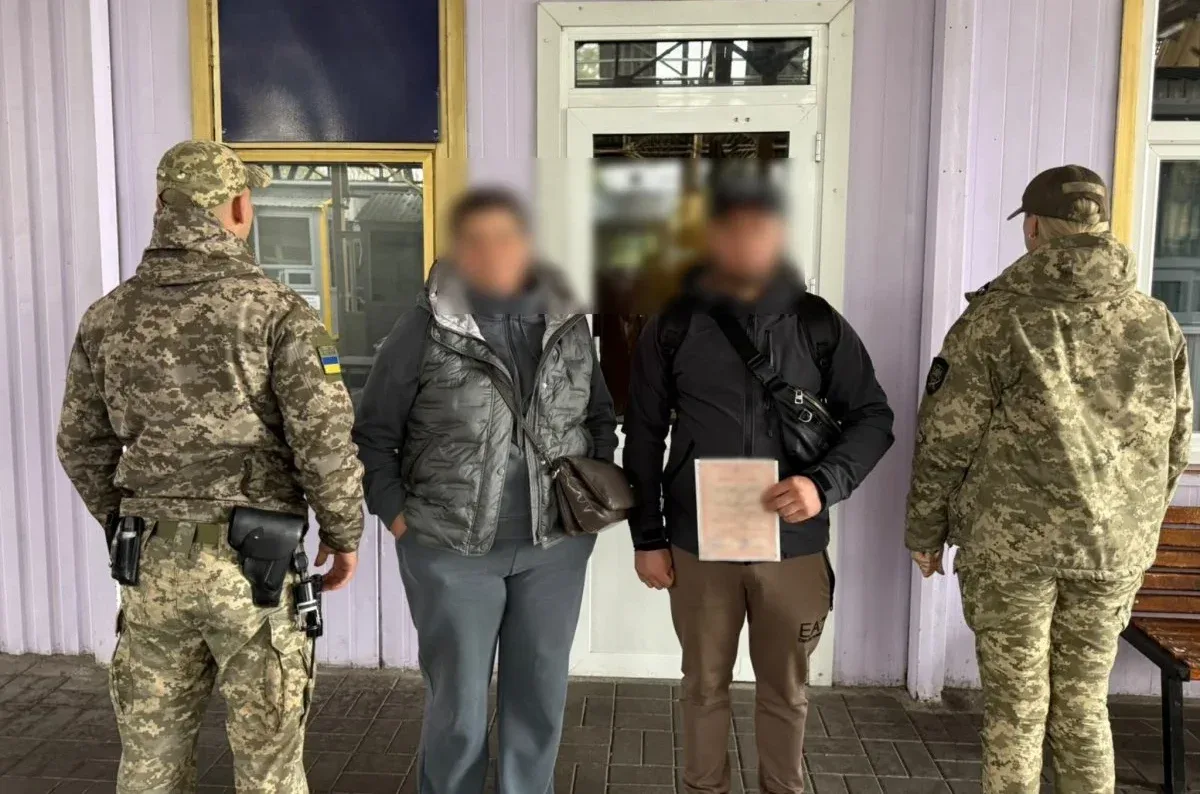 Затримані чоловік та жінка поряд з двома співробітниками ДПСУ