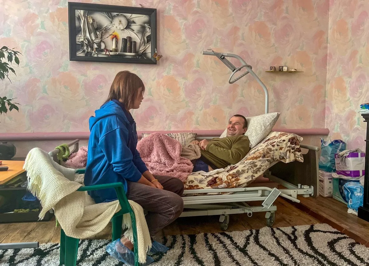 Реабілітологиня Юлія Галунко робить вправи з ветераном Володимиром Фігурним під час реабілітаційного візиту додому.