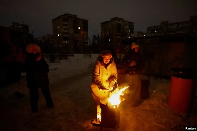 Жителі Києва гріються біля вогнища у дворі під час блекауту, січень 2026 року