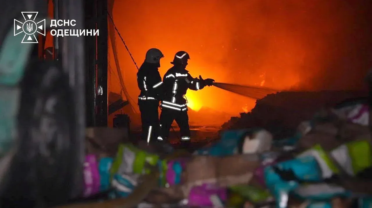Двоє оятувальників гасять пожежу вночі