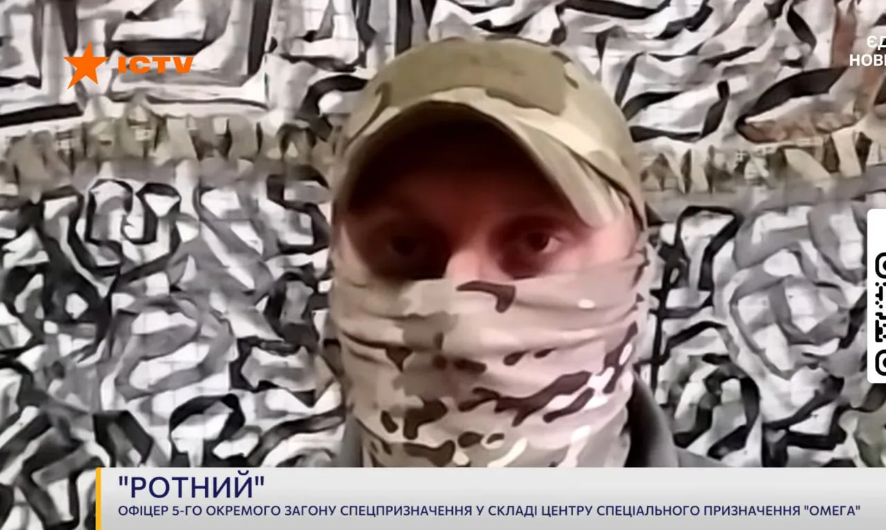 Військовий із позивним «Ротний» у камуфляжній кепці та балаклаві під час інтерв’ю. На екрані зазначено, що він офіцер 5-го окремого загону спецпризначення центру «Омега».