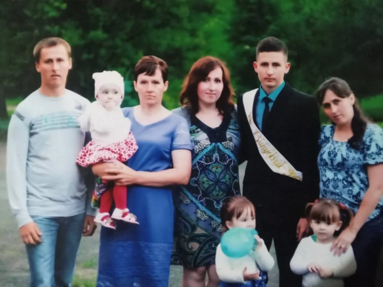 Групове фото Володимира Пилипея з родиною під час випускного: зліва направо — світловолосий брат Роман, мати Світлана з маленькою племінницею майбутнього військового Анастасією на руках, сестра Марія з коротким каштановим волоссям, Володимир із темним волоссям у чорному костюмі та блакитній сорочці, сестра Леся з довгим темним волоссям; попереду — маленькі племінниці Вероніка та Владислава. Фото з архіву родини