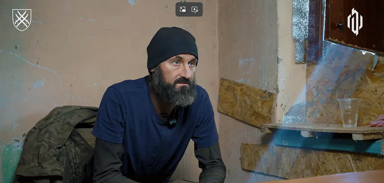 Полонений окупант в шапці сидить на стільці