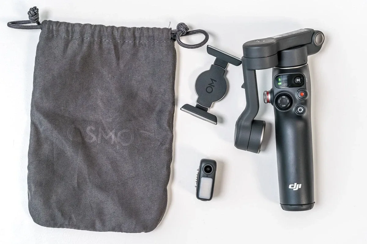 Комплект DJI Osmo Mobile 7P на столе: подвес, чехол, многофункциональный модуль и магнитный зажим