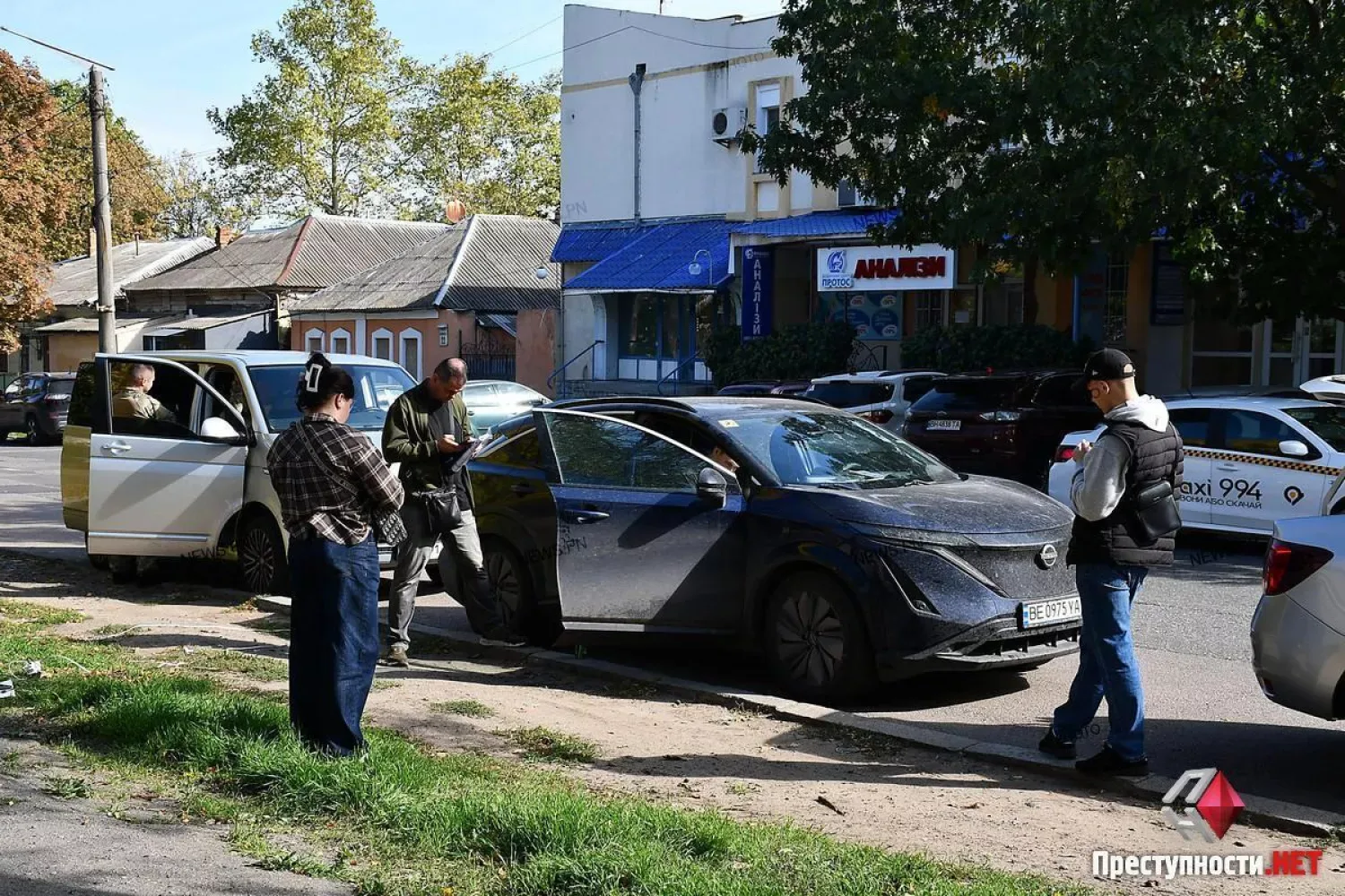 Співробітники з шевронами НАБУ біля автомобіля Nissan у центрі Миколаєва. Фото: ПН